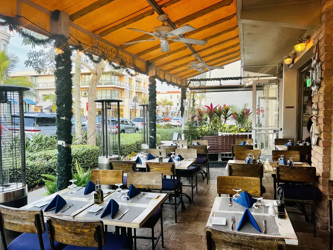 La Pescheria's covered patio with set tables and ceiling fans