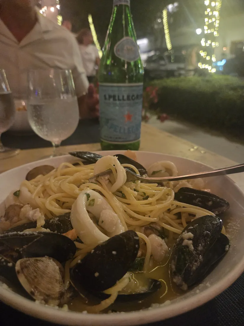 Spaghetti with mussels and squid at an outdoor table